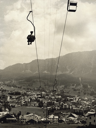 Man Riding Chair Lift Above Town