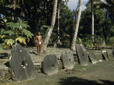 Buy Man Stands Behind Large Stone Disks Treasured as Token Money at AllPosters.com