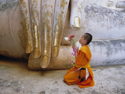 Novice Buddhist Monk Kneeling Beneath the Phra Atchana Buddha Statue, Sukhothai Province, Thailand