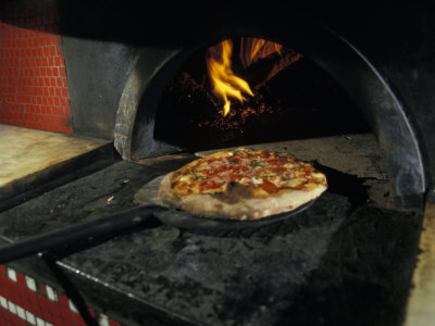 Pizza Comes Out of a Brick Oven in a Restaurant in Rome, Italy