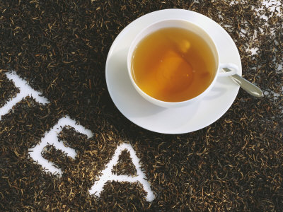 Cup of Black Tea, Surrounded by Tea Leaves with the Word Tea