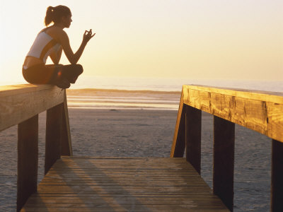 Woman Doing Yoga at Beach During Sunrise