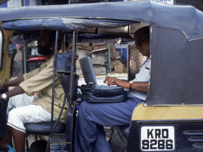 Man Uses Laptop in Back Seat of Rickshaw, India