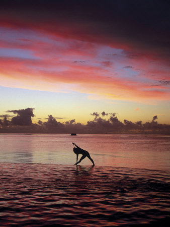 Woman Doing Yoga by Ocean at Sunset