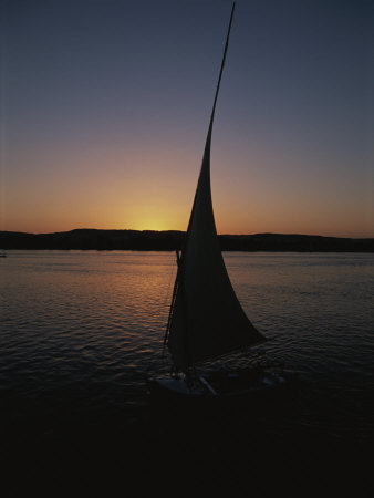 Sunset Outlines the Curve of a Felucca Sail on the Nile River