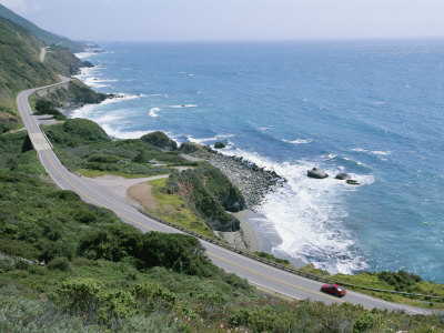 A Car Whizzes Down Hwy 1 Along Californias Big Sur Coastline