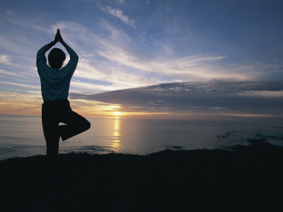 A Woman Practices Yoga on the Beach at Sunset