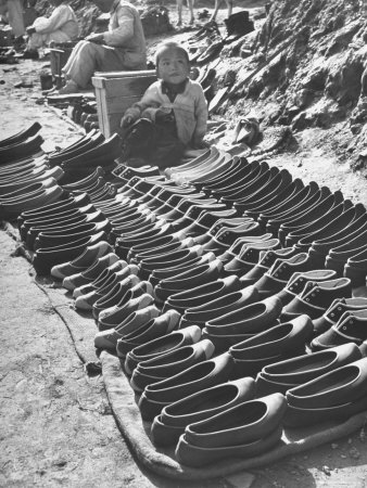 Child Sitting Beside Shoes That Are Being Distributed to Voters Who Pledged Votes in Advance