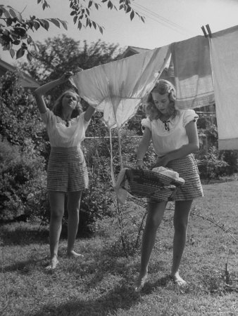 Teenage Twin Girls Hanging Laundry on Clothesline