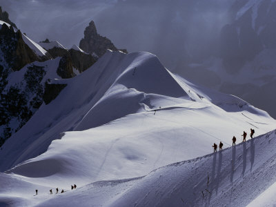 Hikers Follow a Path Across a Snow Field in the French Alps