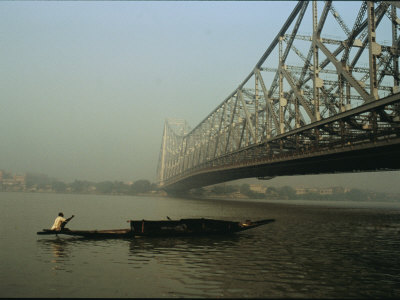 Buy A Man Guides a Boat under a Bridge on the Hooghly River at Calcutta at AllPosters.com