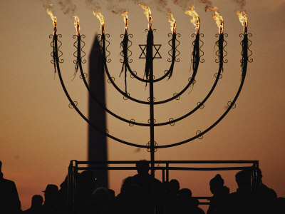 Silhouetted Worshippers Stand Before a Large Menorah Near the Washington Monument