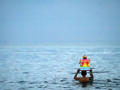 A Devotee Immerses the Idol of Elephant-Headed Hindu God Ganesh