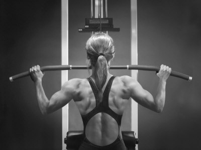 Buy Rear View of a Woman Exercising on a Machine at AllPosters.com