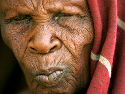A Chadian Woman Made Homeless by Warfare Sits Near Her Hut