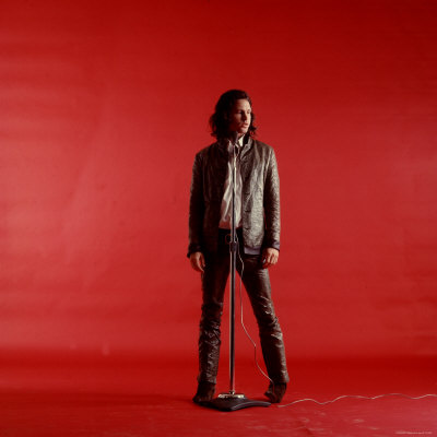 Rock Star Jim Morrison of the Doors Standing Behind Microphone Alone Against a Red Backdrop