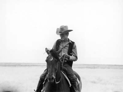 Actor James Dean Clad in Western Garb for His Role, Riding Horse on Location for the Movie "Giant"