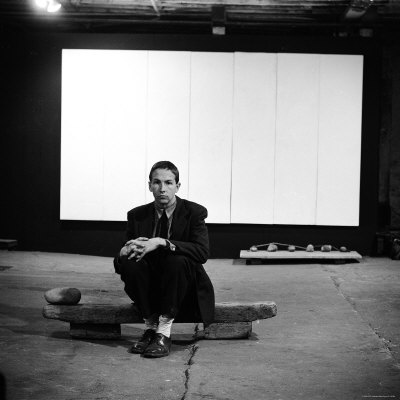 Robert Rauschenberg Sitting on One of His Sculptures in His Studio