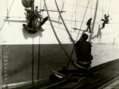 Painters Sitting on Rigging Clean and Paint Side of Ship During Spring Cleaning