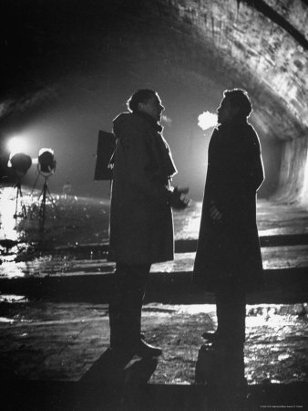 Carol Reed Coaching Orson Welles as They Stand Against Floodlights During Filming "The Third Man."