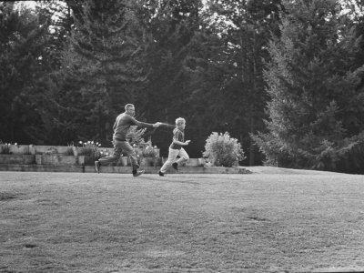 Cartoonist Charles M. Schulz Frolicking with a Friend of His Children at His Estate