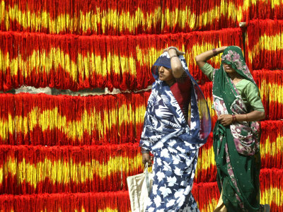 Villagers Walk Past Freshly Dyed Kalawa, a Sacred Orange-Yellow Thread Used in Hindu Rituals