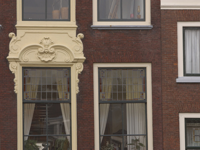 Several Windows with an Ornate Frame on a Red Brick House
