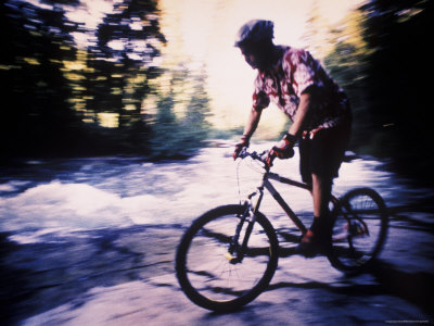 Mountain Biker Riding Along River Bank
