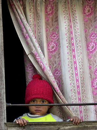 A Nepali Child Looks out from a Window at Pro-Democracy Activists