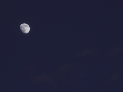 A Dark Blue Sky with the Small Silver Moon Illuminated