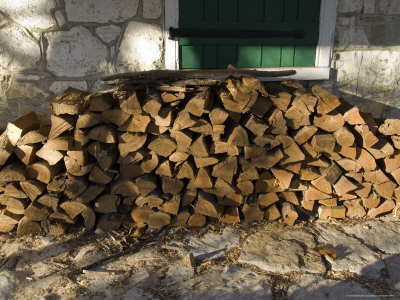 Wood Pile Against a Stone Wall