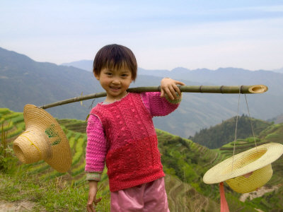 Young Girl Carrying Shoulder Pole with Straw Hats, China