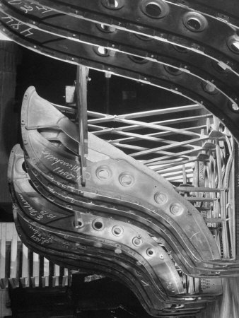 Harp-Shaped Steel String Frames in Racks Waiting to be Installed at the Steinway Piano Factory