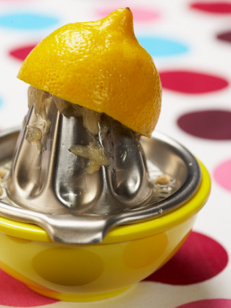 Juicer with Bowl and Lemon Half on Polka Dot Surface