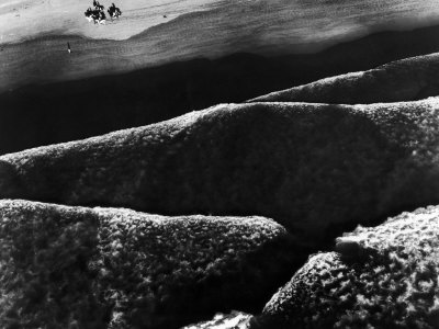 Riders Guiding their Horses Along the Shore as Mountainous Waves of High Tide Roll Shoreward