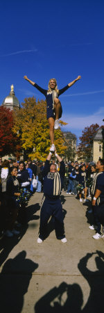 Woman Standing One Leg on a Man Hand and Performing a Stunt, University of Notre Dame Poster