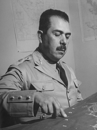 General Lazaro Cardenas, Pointing to a Map as His Continues to Work on a Stradegy