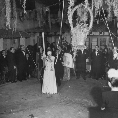 Blind Folded Woman Trying to Split Open the Pinata, During Traditional Pre-Christmas Celebration