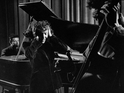 Singer Edith Piaf Holding Her Hands to Her Head While Performing with Pianist and Bass Player