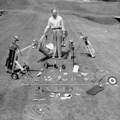 Golf Pro Joe Kirkwood Standing with Various Golf Gadgets