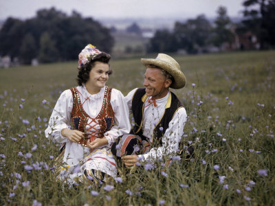 Couple in Polish Costumes Poses in a Field of Wildflowers