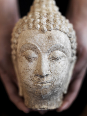 Close-up View of Female Hands Holding a Statue of a Buddha Head