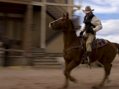 Cowboy Actor Riding a Horse on an Old Western Movie Set