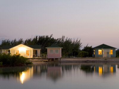 Cozy Beach Cottages at Twilight Casting Reflections in Calm Water