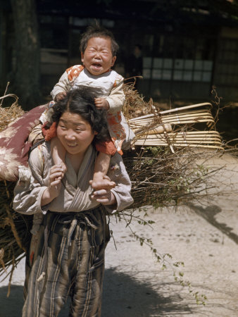 Smiling Mother Carries Her Infant and a Large Bundle of Firewood