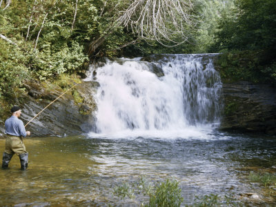 Buy Man in Boots Casts a Line by a Waterfall as He Fishes for Trout at AllPosters.com