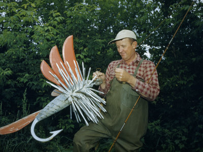 Fishing Tackle Dealer Holds Giant Fly, an Advertisement for His Shop