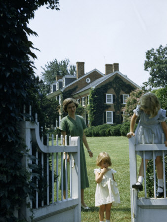 Woman Watches as Girl Climbs Gate Opening onto a Mansion