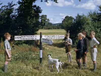 Boys and a Dog Stand by a Signpost Inscribed with the Names of Towns
