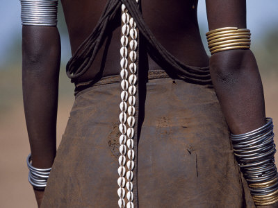 Young Dassanech Girl Wears a Leather Skirt, Metal Bracelets, Amulets and Bead Necklaces, Ethiopia